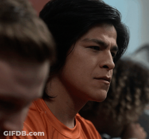 Man In Orange Shirt Looking Sideways GIF