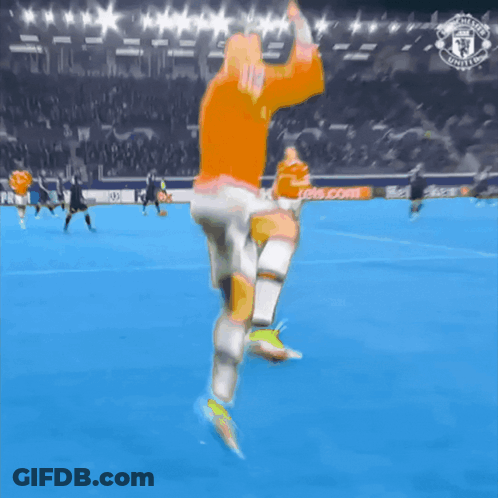 Man In Orange Shirt Running On Soccer Field With Manchester United Logo GIF