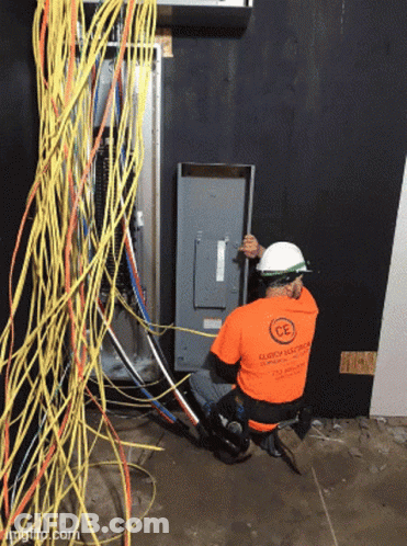 Man In Orange Shirt Saying CE Working On Electrical Panel GIF