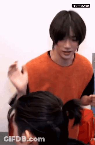 Man In Orange Shirt Standing With Woman GIF