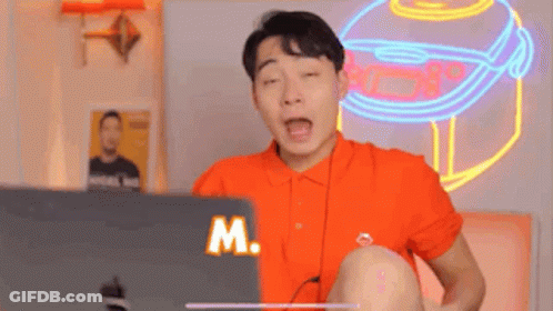Man In Orange Shirt Using Laptop GIF