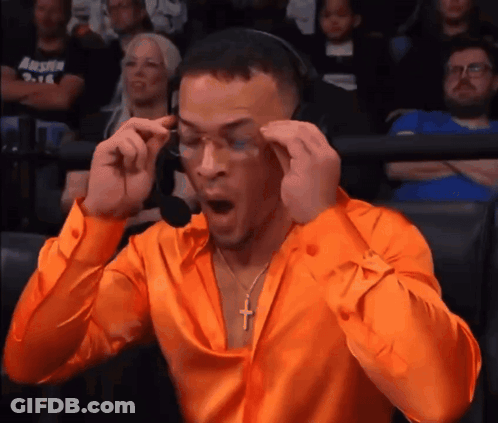 Man In Orange Shirt With Cross Necklace And Headphones GIF