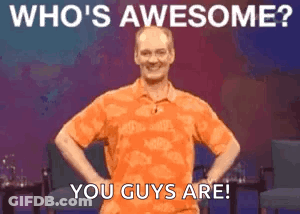 Man In Orange Shirt With Hands On Hips Says Who's Awesome GIF