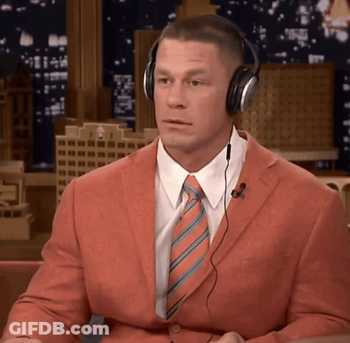 Man In Orange Suit And Headphones Looking At Camera GIF