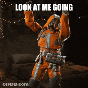 Man In Orange Suit Holding Gun Saying Look At Me Going GIF