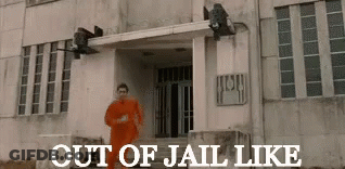 Man In Orange Suit Running In Front Of Out Of Jail Building GIF