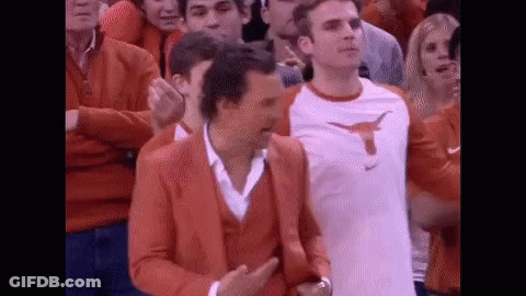 Man In Orange Suit With Longhorn Among Crowd GIF