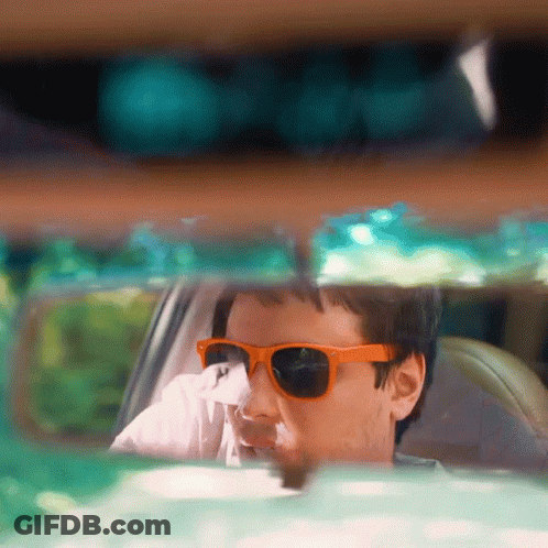 Man In Orange Sunglasses Looking Out Car Window GIF