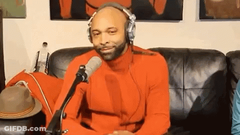 Man In Orange Sweater Wearing Headphones GIF