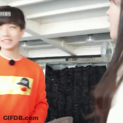 Man In Orange Sweatshirt Talking To Woman GIF