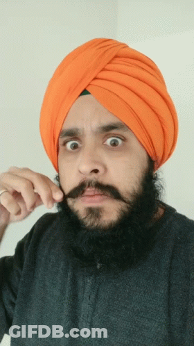 Man In Orange Turban And Black Shirt Holding Mustache GIF