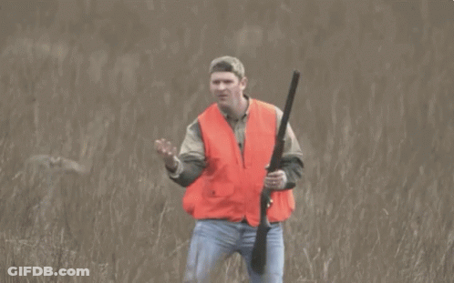 Man In Orange Vest Holding Gun GIF