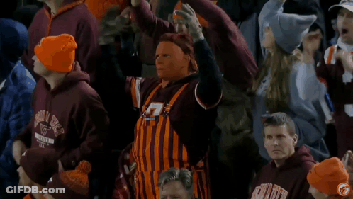 Man In Overalls And Mask In Crowd Wearing VT Hats GIF