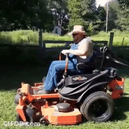 Man In Overalls Riding Lawn Mower GIF