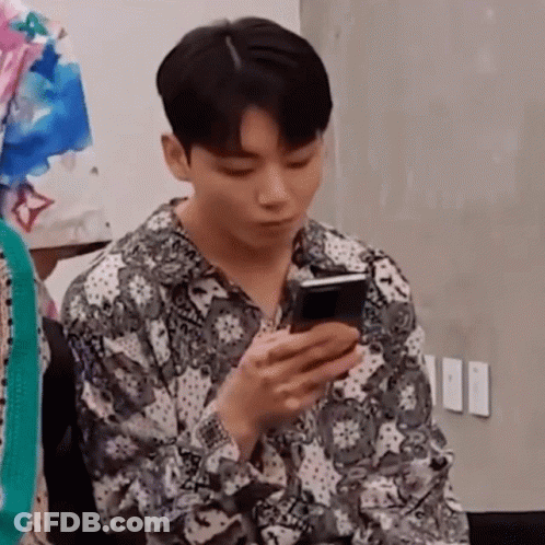 Man In Paisley Shirt Looking At Phone GIF