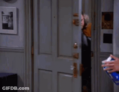 Man In Parka Standing In Doorway While Person Sprays GIF