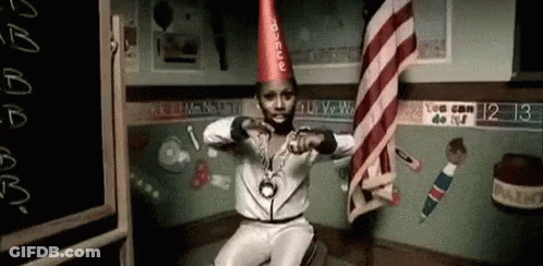Man In Party Hat And Necklace Sitting In Classroom GIF