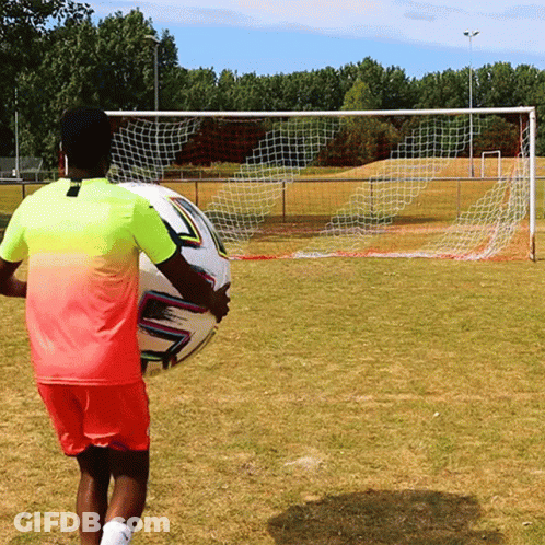 Man In Pink And Yellow Holding Soccer Ball GIF