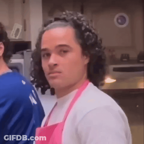 Man In Pink Apron Looking At Camera GIF