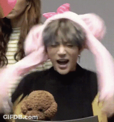 Man In Pink Bunny Hat Holding Stuffed Animal GIF