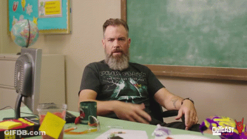 Man In Pink Floyd Shirt Sitting At Desk GIF