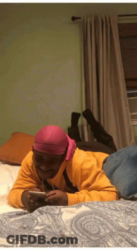 Man In Pink Headband Lying On Bed GIF