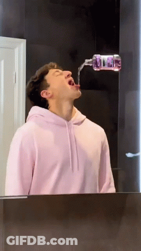 Man In Pink Hoodie Drinking From Bottle GIF