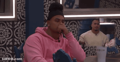 Man In Pink Hoodie With Man In White Shirt Behind GIF