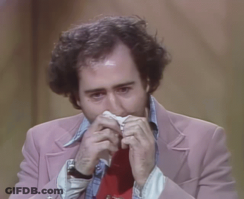 Man In Pink Jacket And Red Tie Holding Paper In Mouth GIF