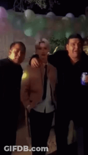 Man In Pink Jacket And Tie Next To Man In Black Shirt GIF