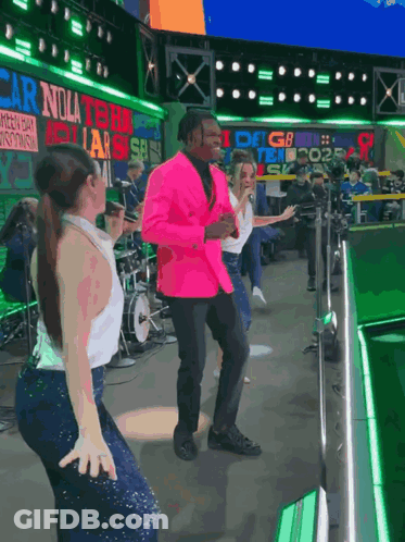 Man In Pink Jacket Dancing In Front Of Carolina Sign GIF
