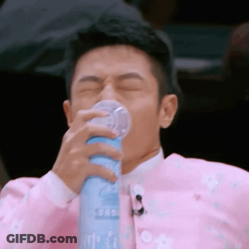 Man In Pink Jacket Drinking From Bottle GIF
