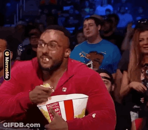 Man In Pink Jacket Eating Popcorn GIF