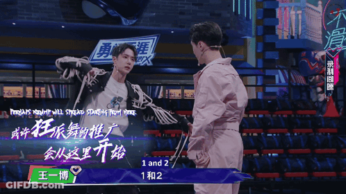 Man In Pink Jacket In Front Of Sign Saying 1 And 2 GIF