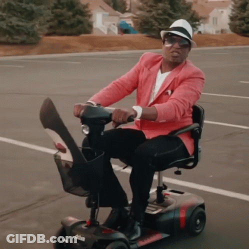Man In Pink Jacket Riding Scooter GIF
