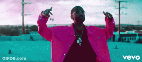Man In Pink Jacket With Arms Outstretched On Roof GIF