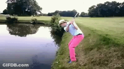 Man In Pink Pants And Hat Swinging Golf Club Over Water GIF