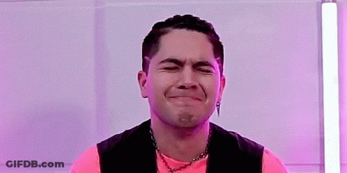 Man In Pink Shirt And Black Vest Making A Face GIF