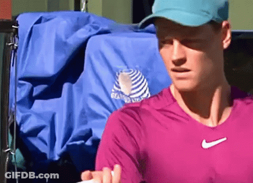 Man In Pink Shirt And Blue Hat Holding Tennis Racket GIF