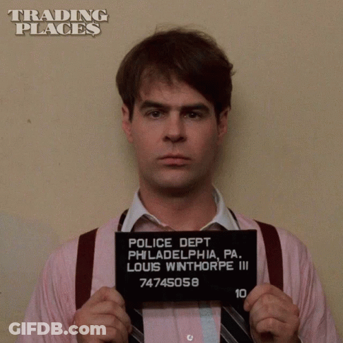 Man In Pink Shirt And Tie Holding Police Mug Shot GIF