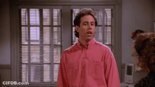 Man In Pink Shirt By Window With Blinds GIF