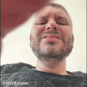Man In Pink Shirt Holding Stick At Microphone GIF