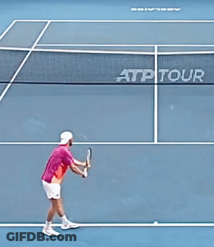 Man In Pink Shirt Holding Tennis Racquet In Crowd GIF