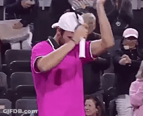 Man In Pink Shirt Holding Tennis Racquet In Front Of Crowd GIF