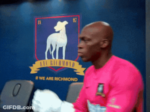 Man In Pink Shirt In Front Of Richmond Wall GIF