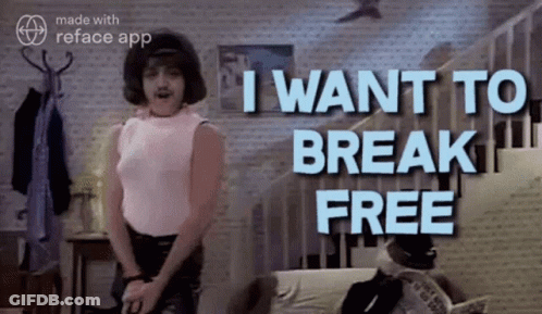 Man In Pink Shirt In Front Of Wall Saying I Want To Break Free GIF