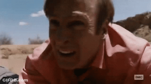 Man In Pink Shirt Laying On Ground Making Face GIF
