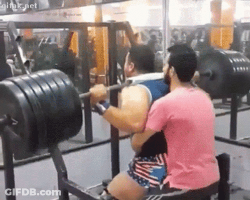 Man In Pink Shirt Lifting Barbell With Onlooker GIF