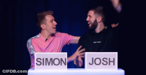 Man In Pink Shirt Next To Man In Black Shirt With Josh Sign GIF