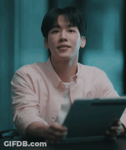 Man In Pink Shirt Sitting At Table With Tablet GIF